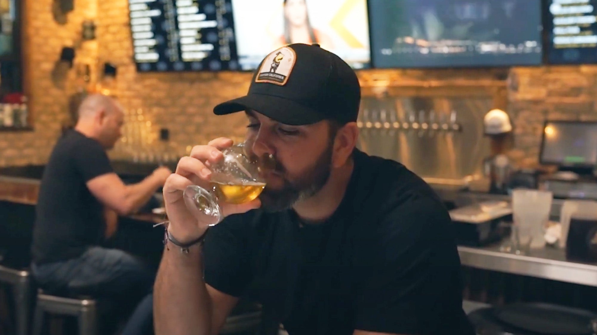 Photo of a man sitting in a dark pub drinking beer