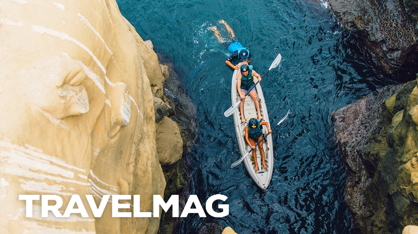 Aerial photo of two people on a kayak entering the mouth of a sea cave in the ocean, on an Everyday California kayak tour.